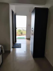 a hallway with a door to a room with a window at Panchgani Palace in Panchgani +2 photos