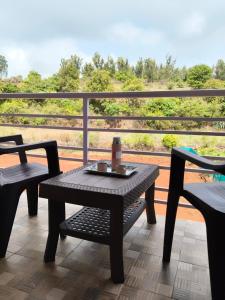 a table and chairs on a balcony with a view at Panchgani Palace in Panchgani +2 photos