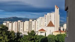 a large white building with a church in front of it at Apartment Ćukušić in Split