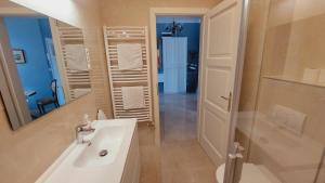 a white bathroom with a sink and a mirror at Castle View in Budapest +7 photos