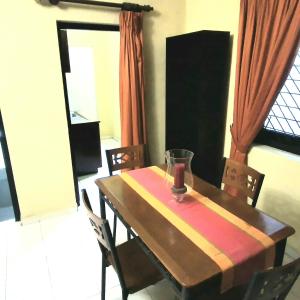 a dining room table with chairs and a wooden table sidx sidx sidx at Urban Retreat Private Ensuite Room in Nikawatawana +3 photos