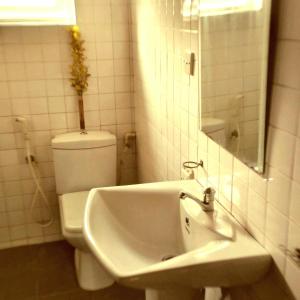 a bathroom with a white toilet and a sink at Urban Retreat Private Ensuite Room in Nikawatawana