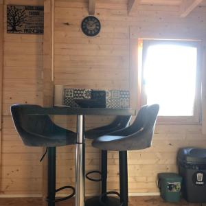 a table and two bar stools in a room at Le chalet des Sarteaux in Ville-sur-Lumes