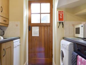 een keuken met een deur en een wasmachine bij Causey View in Keswick