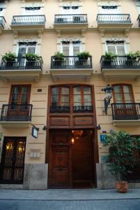 a building with a wooden door and windows at Ad Hoc Monumental 1881 in Valencia