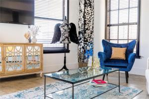 a living room with a blue chair and a glass table at Angel City 1 bedroom Apartment in Los Angeles