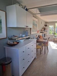 a kitchen with white cabinets and a dining table at House nearby Amsterdam in Almere
