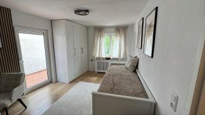 Una habitación blanca con una cama y una ventana en Apartment Tas, en Rottendorf