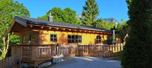 una baita di tronchi con una recinzione in legno di fronte ad essa di Almdorf im Winkl - Blockhüttendorf in Gröbming a Gröbming