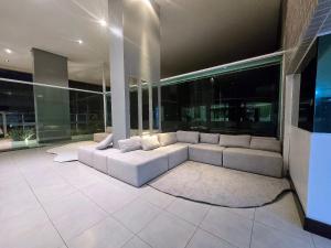 a living room with a white couch in a building at Apê confort no Ed. Manhattan Home Service 2004 in Caruaru +8 photos