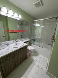 Un baño con lavabo, inodoro y ducha. en Newton Suite, en Surrey