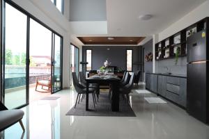 a dining room with a black table and chairs at At Dream Pool Villa in Ban Nong Krathum