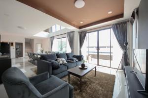 a living room with a couch and a table at At Dream Pool Villa in Ban Nong Krathum