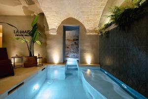 an indoor swimming pool with lights in a building at La Maison - Private wellness in Ostuni