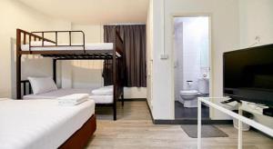 a room with two bunk beds and a television at The rabbit's hole hostel in Bangkok