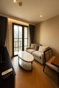 a living room with a couch and a table at Luxury Japanese Onsen Reserve - Bangkok in Bangkok