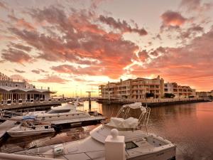 een groep boten aangemeerd in een jachthaven bij zonsondergang bij Krystal Beach Hotel in Gordonsbaai