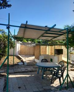 d'une terrasse avec une table et des chaises sous un auvent. dans l'établissement Il trullo della nonna, à Martina Franca