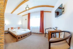 a bedroom with a bed and a table and a window at Resort 7 Crai - Cabana Craiul Crailor in Zărneşti