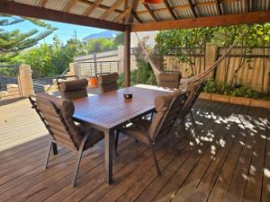 a wooden table and chairs on a deck at Beach Side Retreat in Lancelin