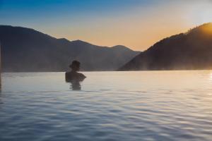 eine Person, die in einem Wasserkörper steht in der Unterkunft Hakone Kowakien Tenyu in Hakone