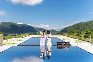 zwei Frauen stehen auf der Spitze einer Aussichtsplattform mit Bergen in der Unterkunft Hakone Kowakien Tenyu in Hakone