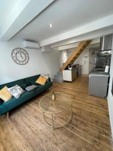 a living room with a green couch and a glass table at Duplex cosy in Chabeuil