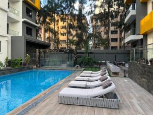 Una piscina con tumbonas al lado de un edificio. en Kilimani Executive Suites With Gym, Heated Pool, Sauna, Steam room, en Nairobi