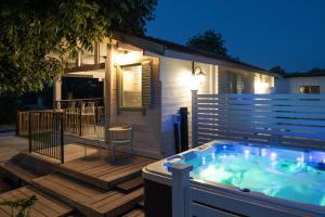a hot tub on a deck in front of a house at הבקתה של רינת in Me‘ona
