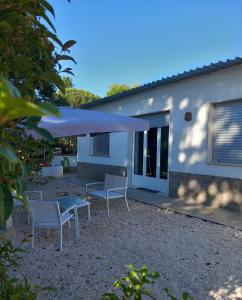 a patio with chairs and an umbrella in front of a house at La casetta in Martina Franca