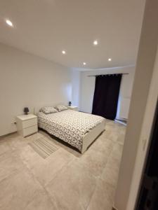 a white bedroom with a bed and a night stand at Le Franchet in Dinant +6 photos
