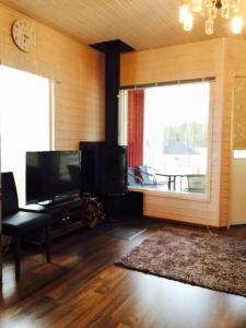 a living room with a television and a large window at Rauha Marina 5 in Imatra