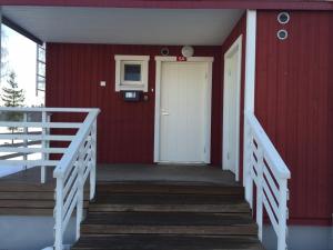 a red house with a white door and stairs at Rauha Marina 5 in Imatra
