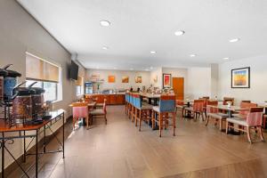 a restaurant with tables and chairs and a bar at Comfort Inn & Suites North Greenfield in Greenfield