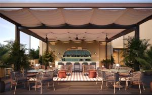 塞米亚克Kleo Seminyak, part of JdV by Hyatt的一个带桌椅的庭院和一间酒吧