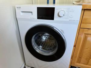 a white washing machine sitting in a kitchen at Camping-Baven-Toven Naturae in (( Bulshizë ))