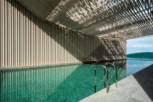 a swimming pool with a large wall of glass at Hyatt Centric Kota Kinabalu in Kota Kinabalu