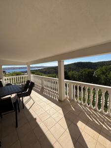 a balcony with a table and chairs and a view at Villa Alexa Cesarica in Cesarica