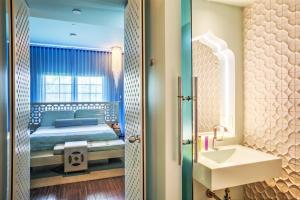 Un dormitorio con una cama, un lavabo y un espejo. en Dream South Beach, by Hyatt, en Miami Beach