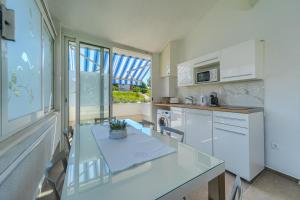 een keuken met een glazen tafel en een wastafel bij Apartments Eternity in Split