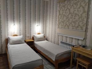 two twin beds in a room with striped walls at Гостевой дом Hotel Allanazar Ota in Khiva