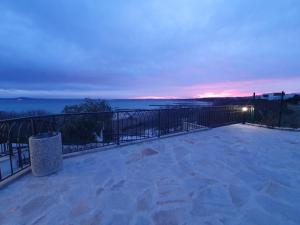 a balcony with a view of the ocean at night at Студио Сарафово in Burgas City