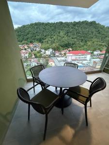 a table and chairs on a balcony with a view at Sole Central Apartment in Râmnicu Vâlcea
