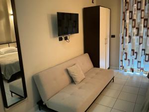 a living room with a white couch and a mirror at Harilla Hotel in Dhërmi