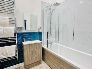 a bathroom with a shower and a sink and a tub at Pastures Barn in Leek +52 photos