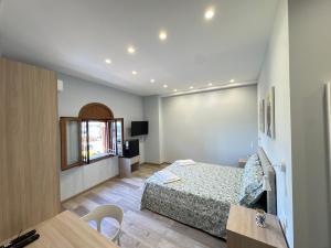 a bedroom with a bed and a desk and a window at Casa Calipso in Catania +95 photos