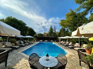 a swimming pool with chairs and a table with at Agrili Apartments & Rooms in Elia