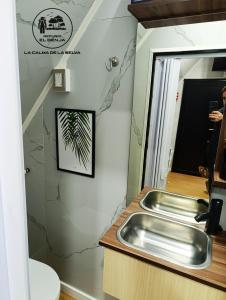 a bathroom with a sink and a mirror at Refugio El Benja in Villa Salto Encantado