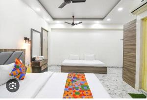a bedroom with two beds and a ceiling fan at hotel Sr royale in Kolkata