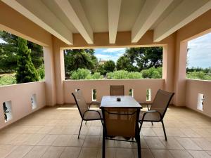a dining room with a table and chairs and windows at Agrili Apartments & Rooms in Elia